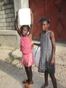 Haitian girls carrying water