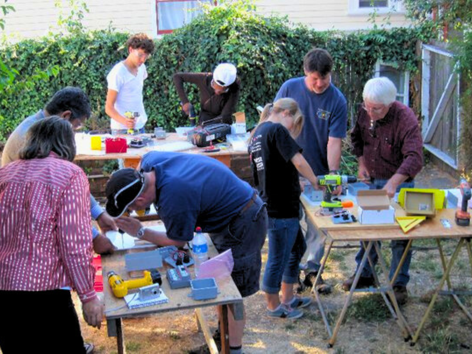 Hal Aronson oversees volunteers building Solar Suitcases in a backyard workshop